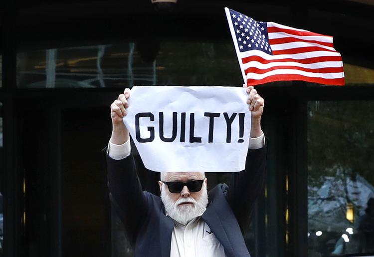 »skyldig«, står der på demonstrant Bill Christesons skilt, da da den dommen falder over Trumps tidligere kampagnechef, Paul Manafort. Han er kendt skyldig i alvorlig økonomisk kriminalitet. Jacquelyn Martin/AP