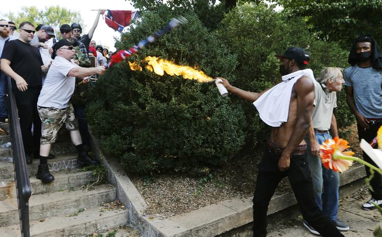 Da en nynazist 12. august sidste år kørte sin bil ind i fredelige demonstranter, udbrød optøjer i Charlottesville. Præsident Trumps tale bagefter om brådne kar på begge sider fik en hård medfart. Og CNNs kommentator ser hans linje fra Charlottesville med at beskytte hvide mennesker fortsætte til det afrikanske kontinent.  Arkivfoto: Steve Helber