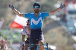 38-årige Alejandro Valverde krydser målstregen som klar vinder af 2. etape i Vuelta a España, mens Michal Kwiatkowski, halvt skjult, må stille sig tilfreds med at erobre førertrøjen. Foto: Unipublic/Luis Ángel Gómez. 