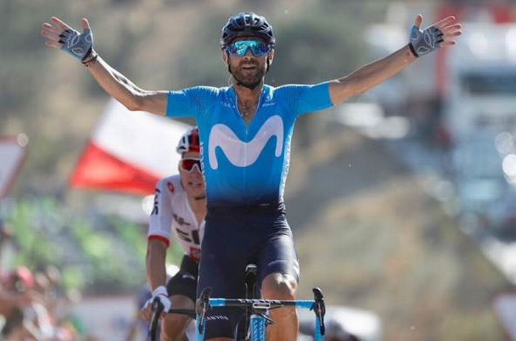 38-årige Alejandro Valverde krydser målstregen som klar vinder af 2. etape i Vuelta a España, mens Michal Kwiatkowski, halvt skjult, må stille sig tilfreds med at erobre førertrøjen. Foto: Unipublic/Luis Ángel Gómez. 