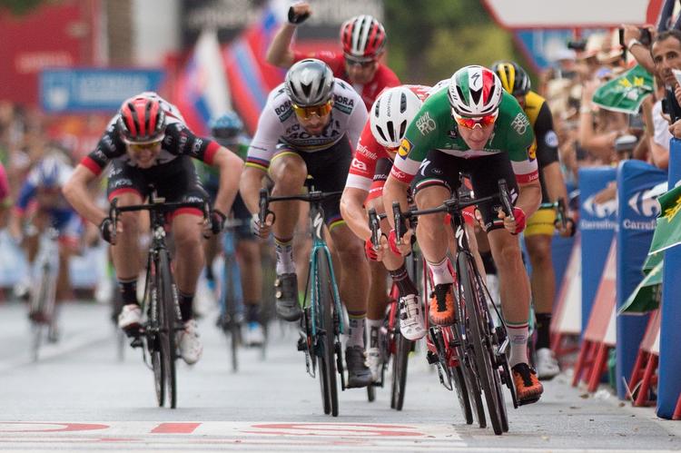 Den italienske mester Elia Viviani tordner mod stregen og sejr på 3. etape, mens hans danske holdkammerat Michael Mørkøv midt i billedet allerede har hævet armen i triumf.
   Jorge Guerrero/Ritzau Scanpix