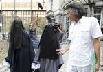 Rachid Nekkaz fotograferet i 2011 i Bruxelles, hvor han taler med to tildækkede søstre, som blev anholdt for at at skjule deres ansigt i det offentlige rum. Yves Logghe/AP