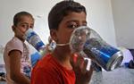 Fordrevne børn i Idlib prøver hjemmelavede gasmasker, der er blevet produceret som en del af forberedelserne på angreb fra den syriske præsident Bashar al-Assads styrker. Muhammad Haj Kadour/Ritzau Scanpix