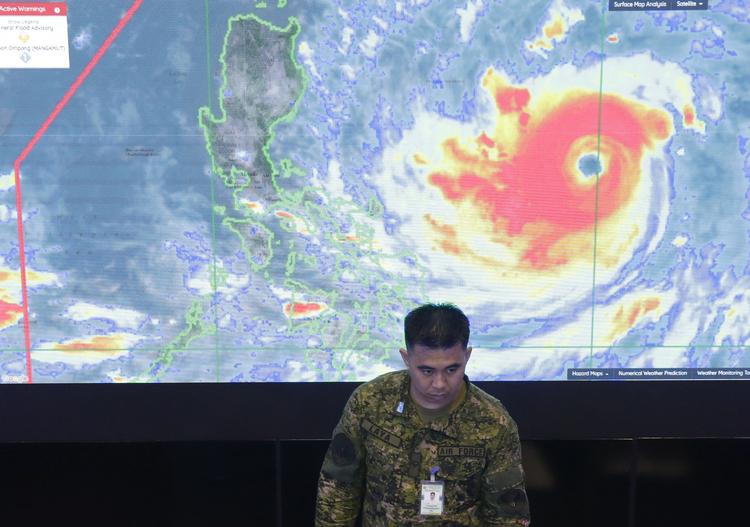 En soldat fra det filippinske luftvåben står foran et satellitbillede af supertyfonen Mangkhut, der nu truer store områder af det sydøstlige Asien. Aaron Favila/AP