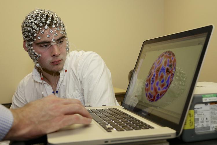 I årtier har der været forsket i at omsætte hjerneimpulser til elektroniske signaler, så man kan måle hjernen eller endda kommunikere direkte ind i en computer. Her er det et forsøg på University of Nebraska i 2013, hvor forskningsassistent Kevin Real studerer sin hjerneaktivitet; målet med forsøget var at udvikle en model, så man hurtigt kunne skanne sportsfolk for hjerneskader. Nh/AP