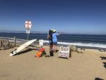 To personer kigger ud på vandet ved Newcomb Hollow Beach i Wellfleet, Massachusetts. En mand blev lørdag bidt af en haj og døde senere af sine kvæstelser. Det er første gang i 80 år, at en person dør som følge af et hajangreb i staten.
   Susan Haigh/AP