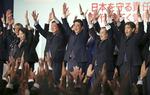 Japans regeringschef, Ahinzo Abe, (i midten) råber 'Banzai' (langt liv) efter sin sejr.  Koji Sasahara/AP
