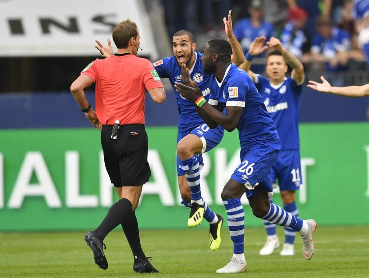 Frustrerede Schalke-spilere med Salif Sané i spidsen forsøger forgæves at overtale dommer Jesus Gil til ikke at dømme straffe.  Martin Meissner/AP