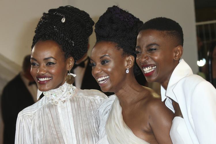 Hovedrolleindehaverne i 'Rafiki', Sheila Munyiva og Samantha Mugatsia, flankerer her instruktøren Wanuri Kahiu til filmens premiere i Cannes i maj. Filmen kan nu endelig få premiere i Kenya. Foto: Joel C Ryan/AP
   Joel C Ryan/AP