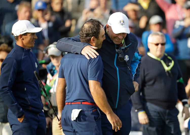 Med Thorbjørn Olesen (tv.) som iagttager uddeler Thomas Bjørn et kram til den ene af de to, der vandt begge fredagens kampe ved Ryder Cup, italieneren Francesco Molinari. Matt Dunham/AP