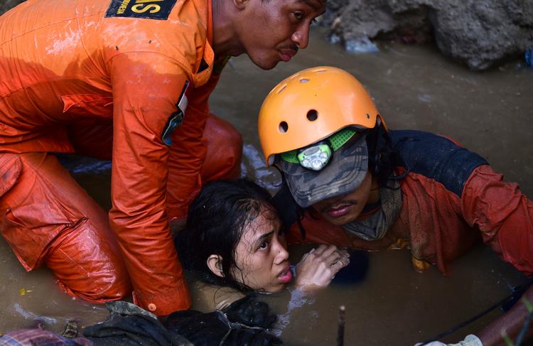En 15-årig pige reddes ud af sit oversvømmede og smadrede hjem i Palu. Foto: AP Photo/Arimacs Wilander Asia516/AP