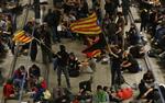 Aktivister svinger det catalanske flag og blokerer jernbanespor i byen Girona for at markere årsdagen for den underkendte uafhængighedsafstemning, der i 2017 endte med massive sammenstød mellem vælgere og politi.
   Manu Fernandez/AP