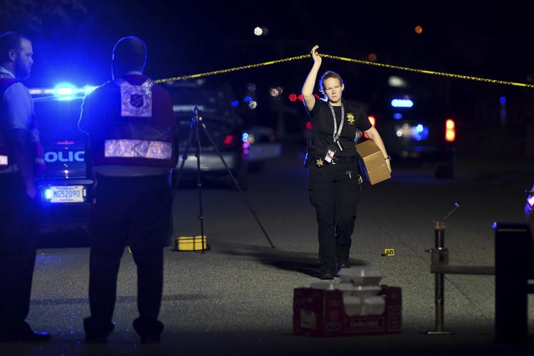 En politibetjent går væk fra gerningsstedet i Florence, South Carolina, hvor adskillige politifolk onsdag blev skudt - herunder en dræbt. Sean Rayford/AP