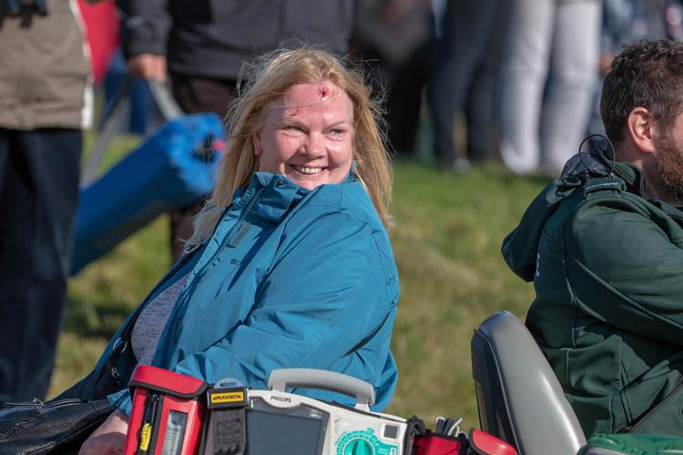 Trods en gevaldig bule i panden var der overskud til at smile, da denne kvindelige golftilskuer blev bragt til yderligere behandling på Kingsbarns i Skotland,. Kenny Smith/AP