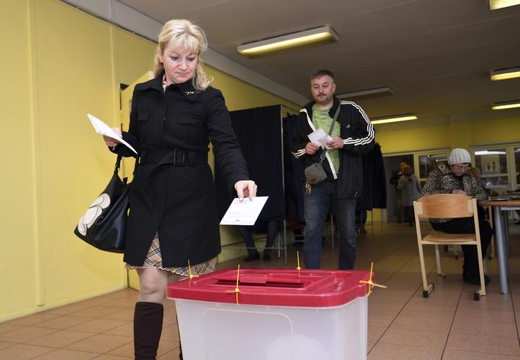 En lettisk kvinde indleverer sin stemmeseddel i forbindelse med valget i Letland. En tidlig valgstedsmåling tyder på, at letterne giver det prorussiske parti Harmoni knap 20 pct. af stemmerne.
    A Latvian woman casts her ballot papers at a polling station in Riga, Latvia, Saturday, Oct. 6, 2018. Latvians were casting their ballots on Saturday in a parliamentary election in which a party catering to the Baltic nation's large ethnic-Russian minority is expected to win the most votes, but is seen to be struggling to find coalition partners. (AP Photo/Roman Koksarov)
   Roman Koksarov/AP