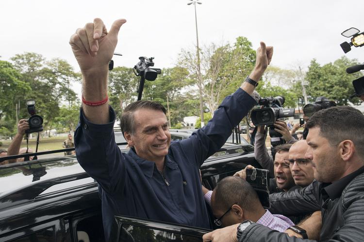Frontløber ved Brasiliens præsidentvalg, Jair Bolsonaro, der rækker ud til sine støtter ved et valgsted i Rio De Janeiro, 7. oktober, 2018. Leo Correa/AP