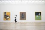 En museumsgæst foran tre malerier af den britiske maler Francis Bacon udstillet i Schweiz.  Patrick Straub/AP