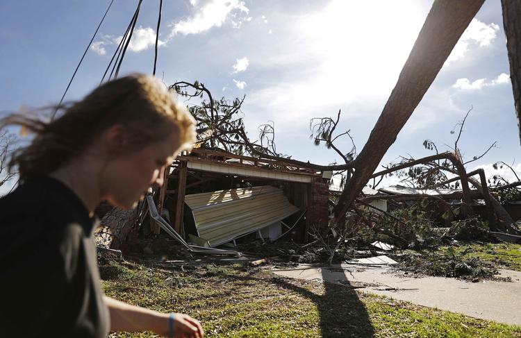En lokal beboer,    Kelsey Gronbeck, passerer ødelagte huse, efter hun har tjekket, en vens hus i Callaway, Florida i kølvandet på orkanen Michael.   David Goldman/AP