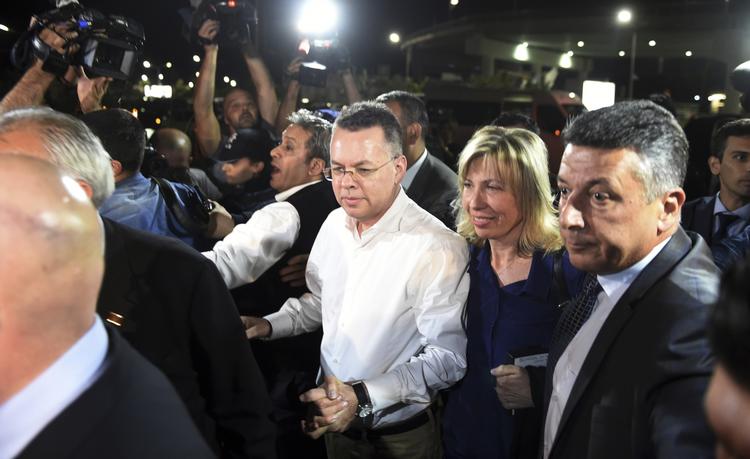 Andrew Brunson i hvid skjote sammen med sin hustru, Norine Brunson, i lufthavnen inden afgangen mod først Tyskland og siden USA. Emre Tazegul/AP