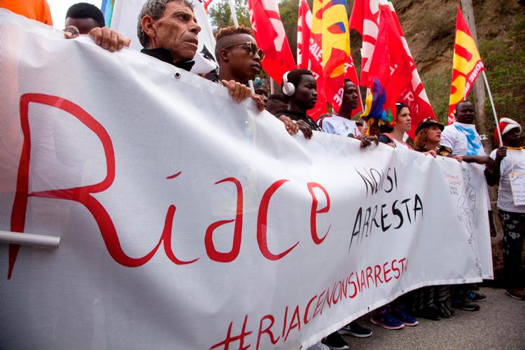 Protest. Efter arrestationen af borgmester Lucano fra byen Riace i oktober sidste år protesterede migranter  og lokale. 'I kan ikke arrestere Riace', hed det på et banner. Foto: Marco Costantino /ANSA via AP) Marco Costantino/AP
