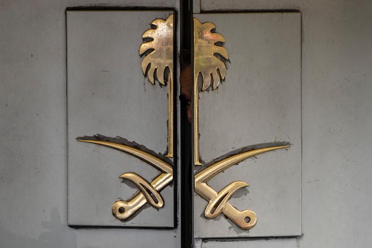 En saudisk ansat ved Saudi-Arabiens konsulat i Istanbul kigger ud gennem konsulatets port. 2. oktober gik journalisten Jamal Khashoggi ind ad porten og er ikke set siden. Yasin Akgul/Ritzau Scanpix