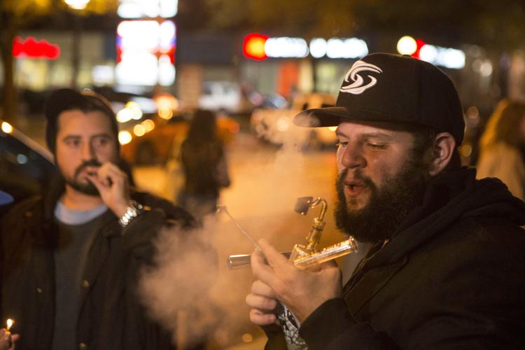 
    Folk ryger hash på gaderne i Toronto efter at cannabis er blevet legaliseret i Canada
d. (Chris Young/The Canadian Press via AP)
   Chris Young/AP