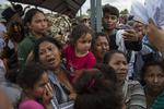 Snesevis af kvinder og børn, der lørdag ventede ved grænsehegnet mellem Guatemala og Mexico, har fået lov til at komme ind i Mexico. Oliver de Ros/AP