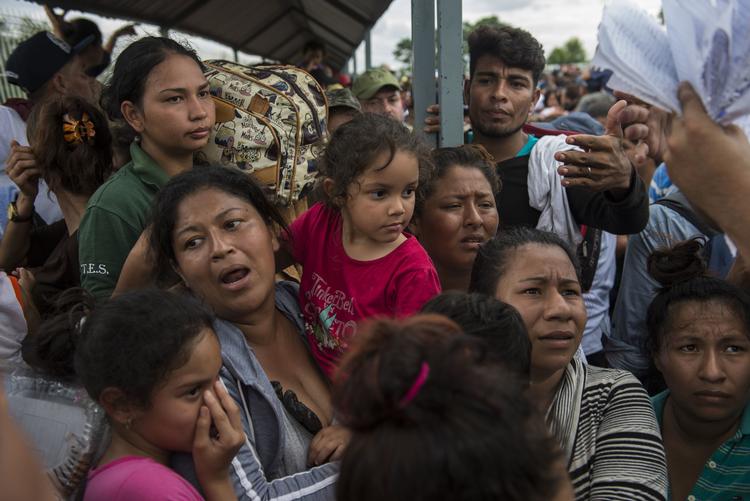 Snesevis af kvinder og børn, der lørdag ventede ved grænsehegnet mellem Guatemala og Mexico, har fået lov til at komme ind i Mexico. Oliver de Ros/AP