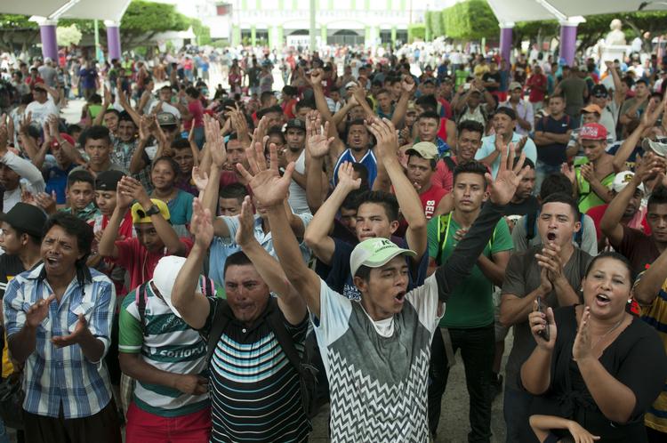 En stor gruppe migranter trængte fredag forbi politiet på en grænsebro mellem Guatemala og Mexico med kurs mod USA. Nu vil de fortsætte mod USA. Oliver de Ros/AP