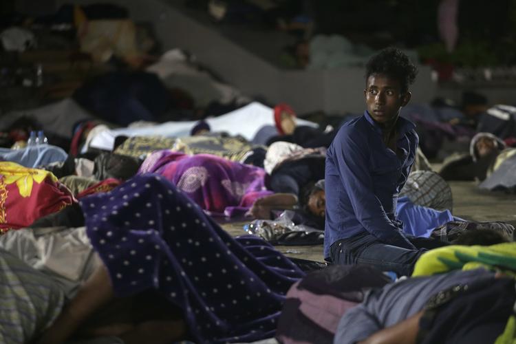 
   En af de mange tusinde migranter, som lige nu er på vej mod USA sidder her blandt en gruppe af sovende fæller. Her i Tapachula i  Mexico . (AP Photo/Moises Castillo)
   Moises Castillo/AP