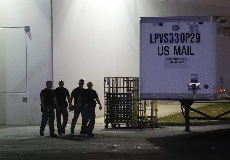 Bombeeksperter fra Miami-Dade ses uden for den postterminal, der lige nu er central i jagten på manden bag en halv snes brevbomber. Wilfredo Lee/AP