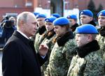 Præsident Putin hilser i søndags på medlemmer af den såkaldte Yunarmia, unge arme, som skal opildne patriotisme i ungdommen. Nu er han anklaget for at have hyret pensioneret oberst i Østrig som spion. Mikhail Klimentyev/AP