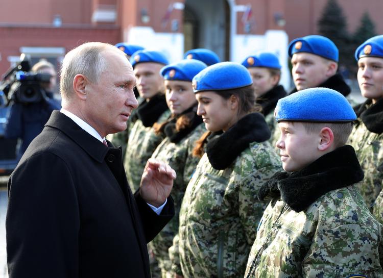 Præsident Putin hilser i søndags på medlemmer af den såkaldte Yunarmia, unge arme, som skal opildne patriotisme i ungdommen. Nu er han anklaget for at have hyret pensioneret oberst i Østrig som spion. Mikhail Klimentyev/AP