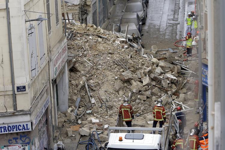 Brandmænd arbejder på stedet, hvor to bygninger er styrtet sammen i Marseille i Sydfrankrig. To forbipasserende kom til skade. Claude Paris/AP