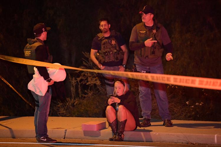 Politiet taler med potentielle vidner i nærheden af baren, hvor en mand gik amok med skydevåben. Mark J. Terrill/AP