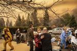 Sygeplejeste Cassie Lerossignol krammer med en kollega mens Feather River Hospitalet brænder. Noah Berger/AP