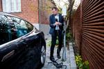 Kasper Jacoby ved elbilens oplader, der ikke er forbundet til husets elsystem. Men i sommer, da solcellerne på husets tag producerede rigtig meget strøm, opladede familien nogle gange bilen fra et stik i huset for at udnytte solen. Andreas Haubjerg/POLFOTO