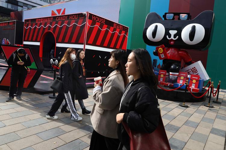 Kinesiske forbrugere går i Beijing forbi en reklame, der promoverer Alibabas Singles Day-udsalg. Ng Han Guan/AP