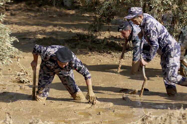 Jordanske redninsarbejdere leder efter savnede i Madaba-området, efter at voldsom regn har skabt farlige oversvømmelser, som har kostet mindst 12 mennesker livet. Raad Adayleh/AP