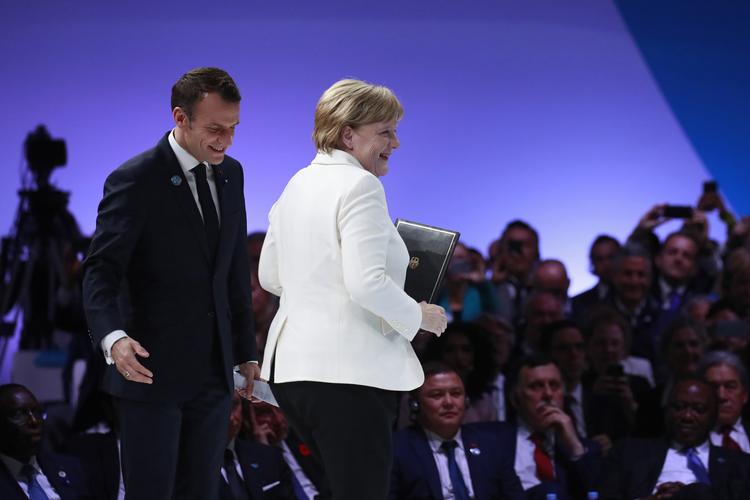 Emmanuel Macron og  Angela Merkel under åbningen af søndagens fredskonference i Paris.  Gonzalo Fuentes/AP