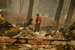 
    Redningsarbejder Noelle Francis og hendes hund søger efter overlevende.  Skovbranden har her hærget et mobil home område i Paradise, Californien.  (Hector Amezcua/The Sacramento Bee via AP)
   Hector Amezcua/AP