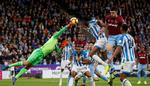 Huddersfield-målmand Jonas Lössl  bokser væk for næsen af Mathias 'Zanka' Jørgensen - to danskere, der gør det godt i England. I fremtiden bliver det sværere, at få en kontrakt i England, da der kommer nye regler. Russell Cheyne/Ritzau Scanpix