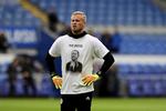 Målmand i Leicester City, Kasper Schmeichel, bærer en t-shirt med billedet af klubejer Vichai Srivaddhanaprabha under opvarmningen til den første kamp, efter Srivaddhanaprabha mistede livet i en helikopterulykke, kort efter den var lettet fra  King Power Stadium. Simon Galloway/AP