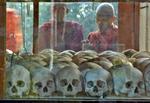Buddhistmunke ser på kranier i Choeung Ek-folkedrabsmuseet i Phnom Penh. Arkivfoto. David Longstreath/AP