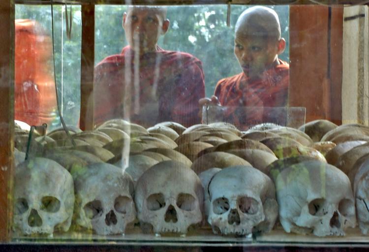 Buddhistmunke ser på kranier i Choeung Ek-folkedrabsmuseet i Phnom Penh. Arkivfoto. David Longstreath/AP