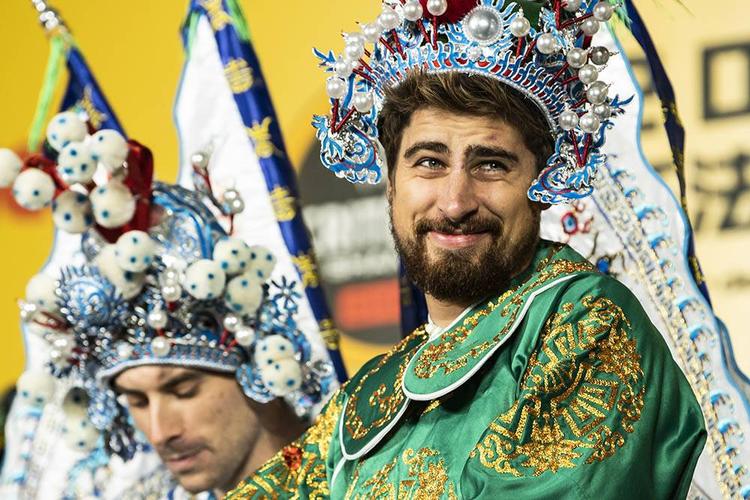 Inden det gik løs på cyklerne optrådte rytterne i diverse kulturelle arrangementer, og Peter Sagan ser ud til at befinde sig ganske godt i denne kinesiske folkedrag - i grønt naturligvis - mens franskmanden Pierre Latour ser en anelse mere betænkelig ud. Foto: A.S.O/P. Ballet. 