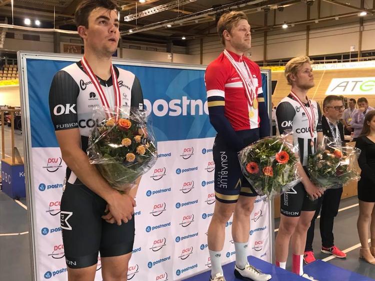 Lasse Norman hyldes iklædt Dannebrogstrikoten efter for fjerde gang af have vundet DM-titlen i pointløb foran Casper Folsach (t.v.) og Julius Johansen. Foto: CyclingWorld.dk 