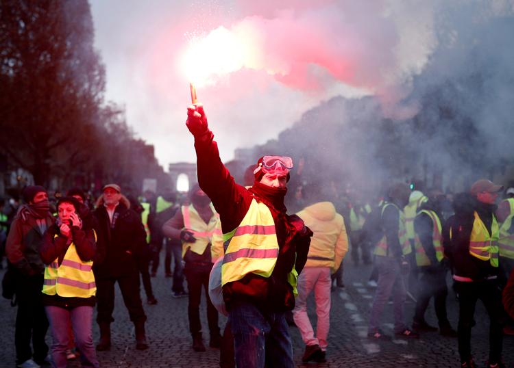 Demonstranter med guleveste, et symbol på franske chaufførers protester mod højere brændstofpriser, på gaden i Paris.
   Foto: Benoit Tessier/Ritzau Scanpix
