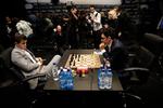 Tilbagelænet i det grå jakkesæt sidder den tredobbelte verdensmester, Magnus Carlsen, og venter på sin modstander. Det gjorde han mange gange under mandagens opgør, hvor Fabiano Caruana brugte god tid på sine træk. Foto: Matt Dunham/AP