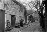 Det var så dén jul! Sne er der ikke skyggen af i arbejderkvarteret omkring Frederiksholms Kanal, og juletræet er røget ud på gaden. Pigen, træet og gaden er formentlig fotograferet i 1920'erne af Politikens allestedsnærværende Holger Damgaard. Foto: Holger Damgaard/POLFOTO